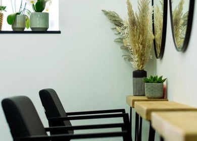 Modern salon seating at R&R Organic Hair, London, England, GB, with plant decor and mirrors enhancing ambiance.