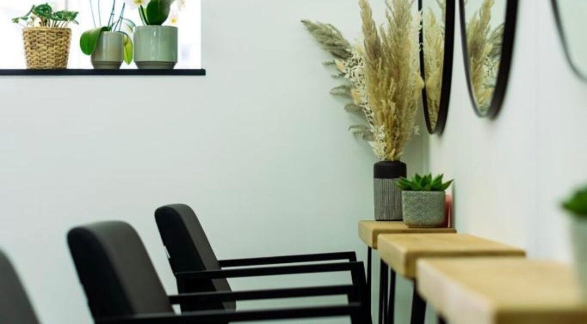 Modern salon seating at R&R Organic Hair, London, England, GB, with plant decor and mirrors enhancing ambiance.