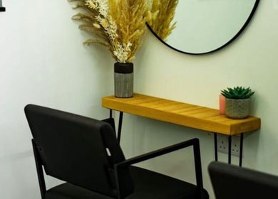 Stylish black chair and green decor in R&R Organic Hair, London, England, GB salon corner.