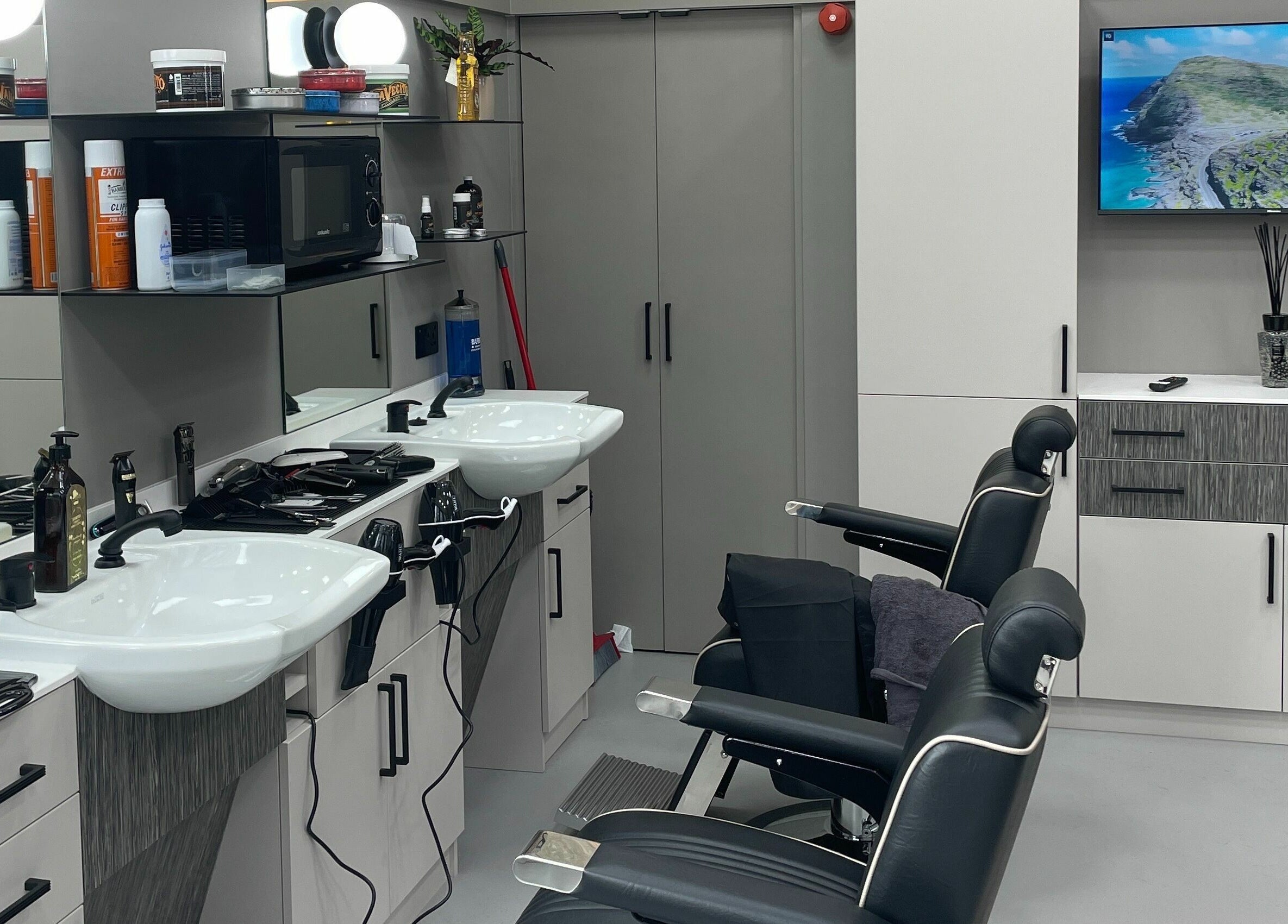Modern salon interior at Hair Authors in London, England, GB, showcasing stylish hairdressing chairs and sleek mirrors.