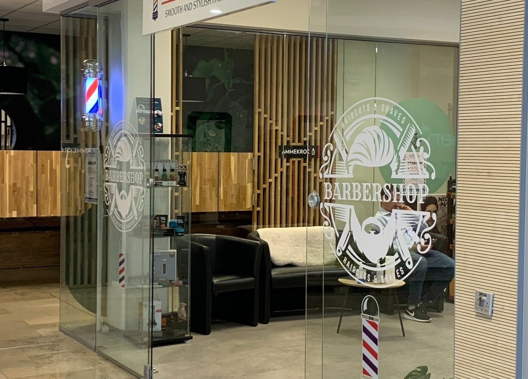 Moderne ingang til Mo's Barber i Oslo, Oslo, NO med glasspaneler og stilrent interiør.