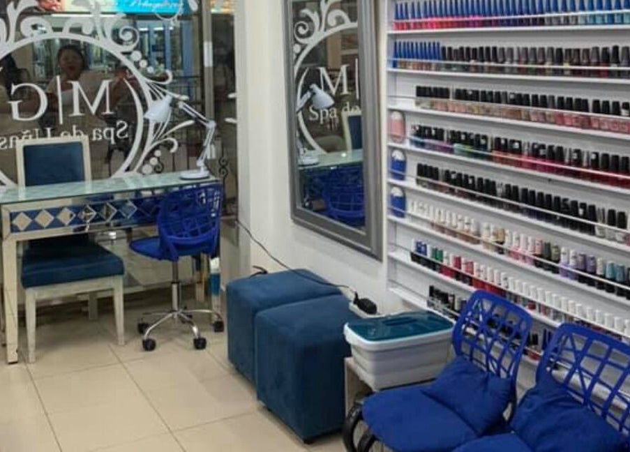 Interior de MG Spa de Uñas Manga, Cartagena, Bolívar, CO, con sillas azules y estantes de esmaltes coloridos.