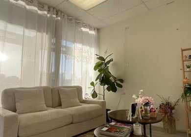 Inviting waiting area at Magiclash Brea, Brea, California, US, with a plush sofa and warm lighting.