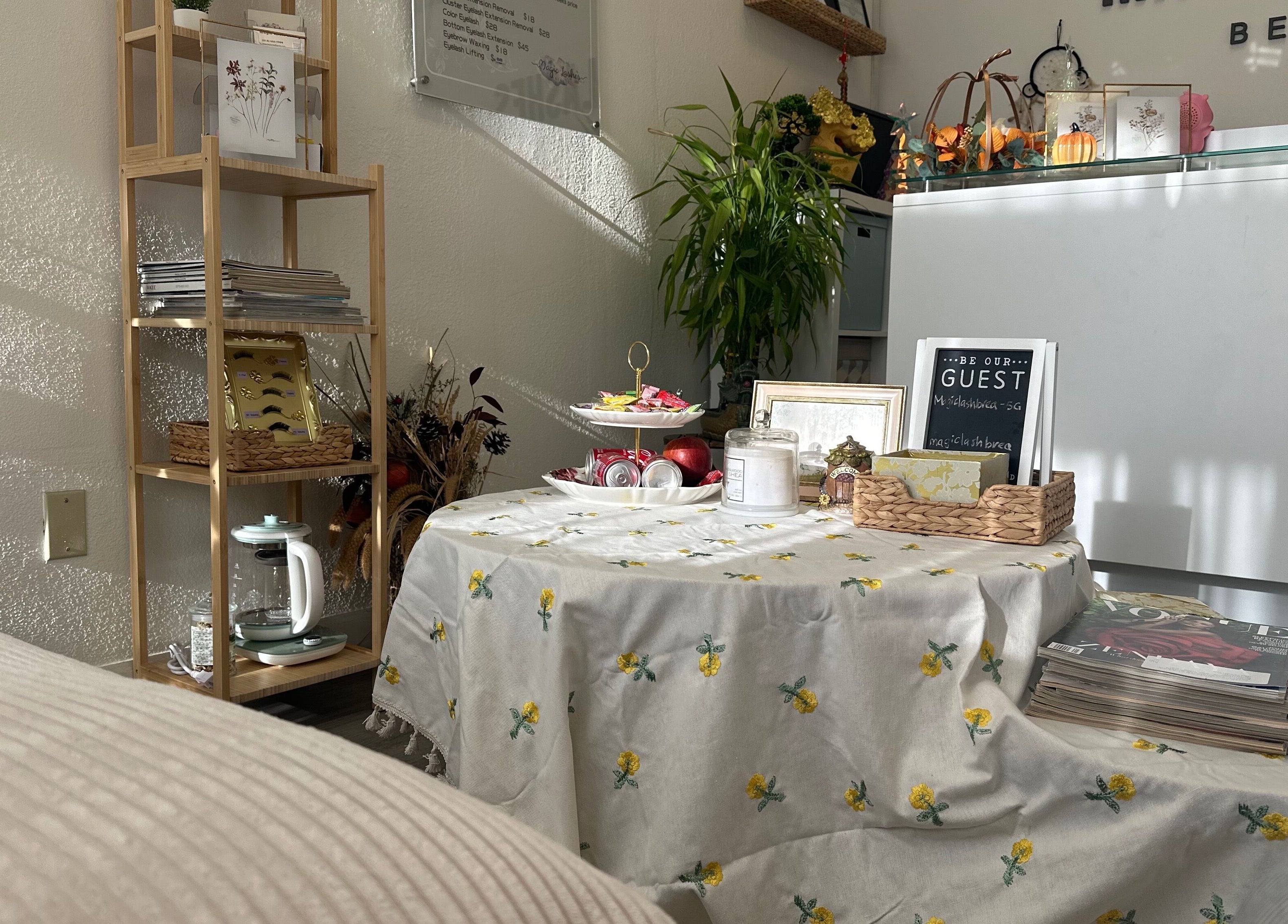 Inviting corner at Magiclash Brea, Brea, California, US, featuring a decorative table with greenery and magazines.