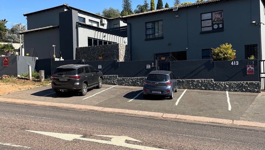 Exterior of The Hair Scene, Pretoria, Gauteng, ZA with parking space and sleek design.