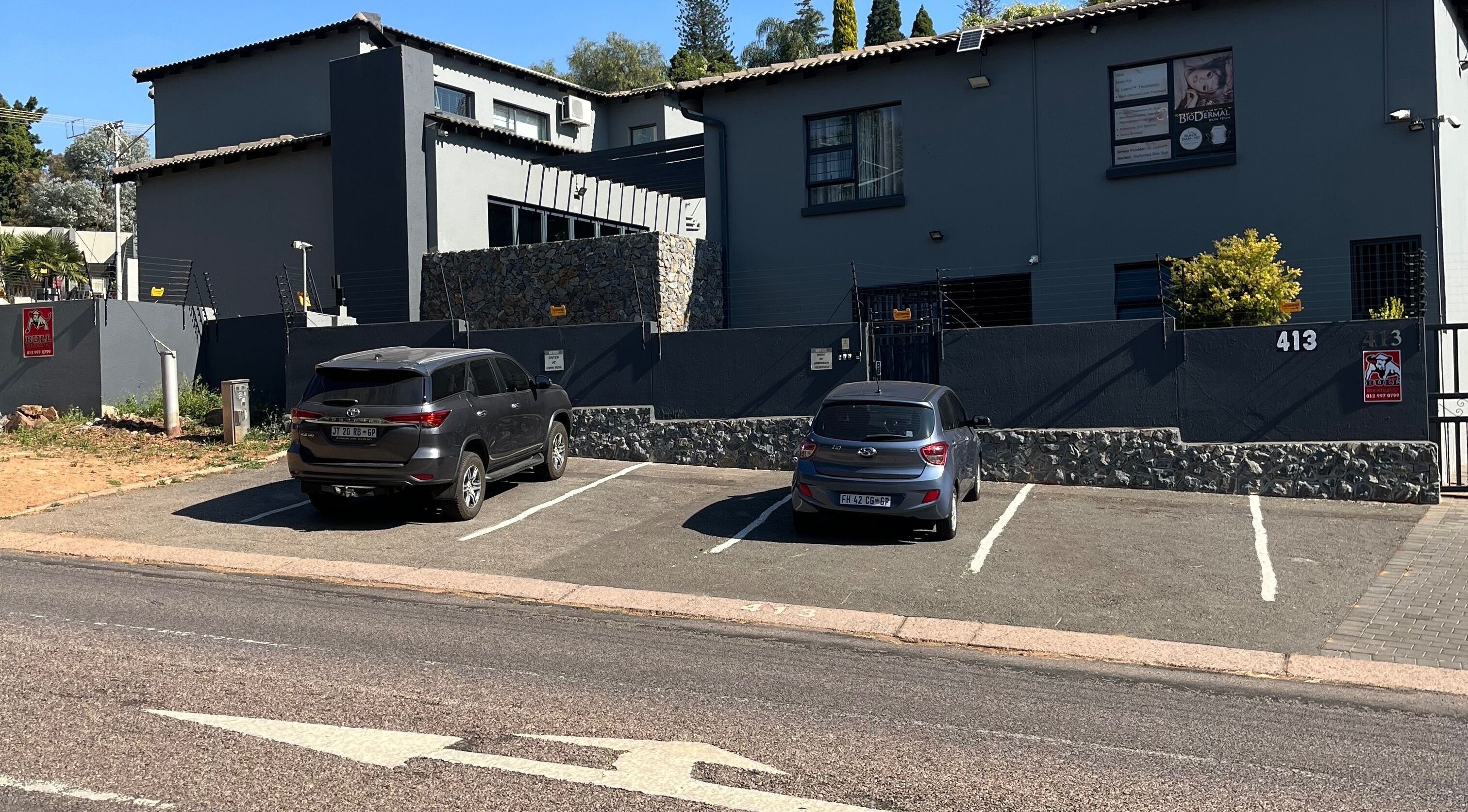 Exterior of The Hair Scene, Pretoria, Gauteng, ZA with parking space and sleek design.