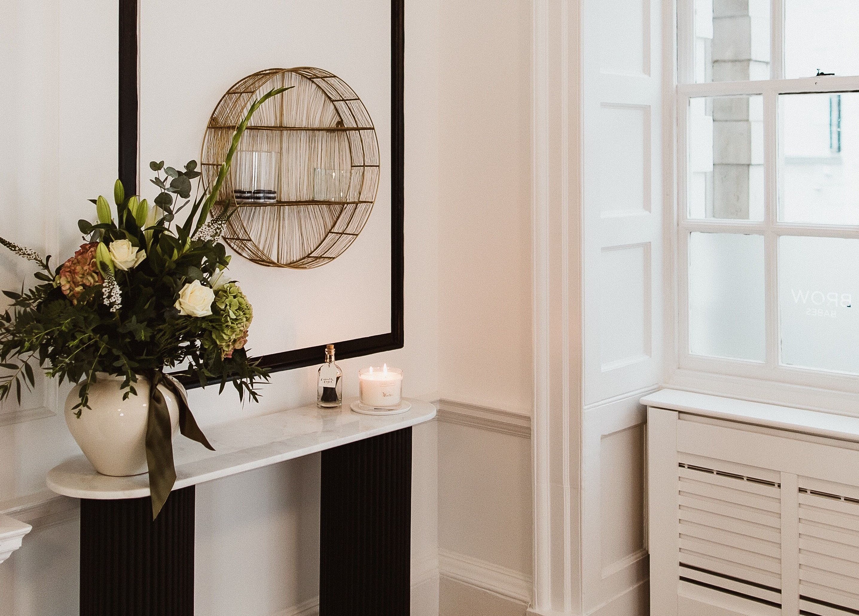 Chic interior at Brow Babes - Harry in Truro, England with elegant floral arrangement and candle.