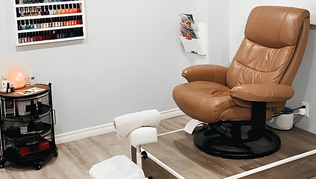 Cozy pedicure chair at Esthetics by Nikki, Hamilton, Ontario, CA, with a nail polish display in view.