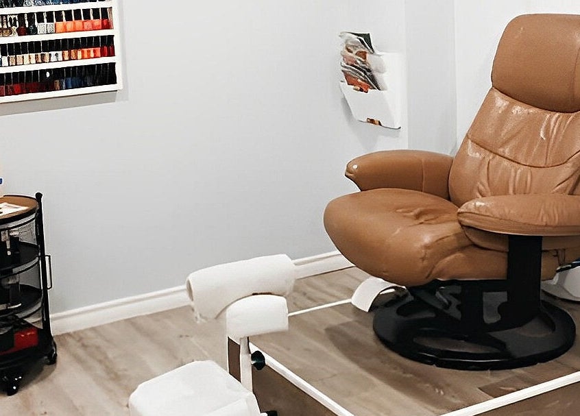 Cozy pedicure chair at Esthetics by Nikki, Hamilton, Ontario, CA, with a nail polish display in view.