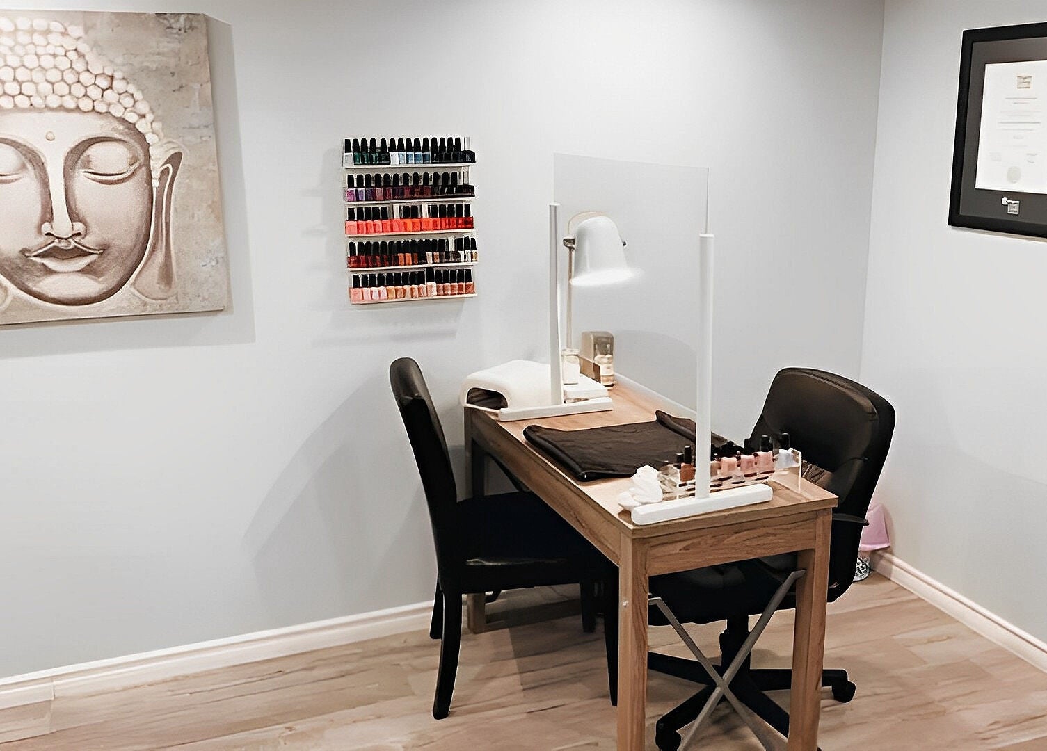 Nail station at Esthetics by Nikki in Hamilton, Ontario, CA, featuring a serene Buddha painting.