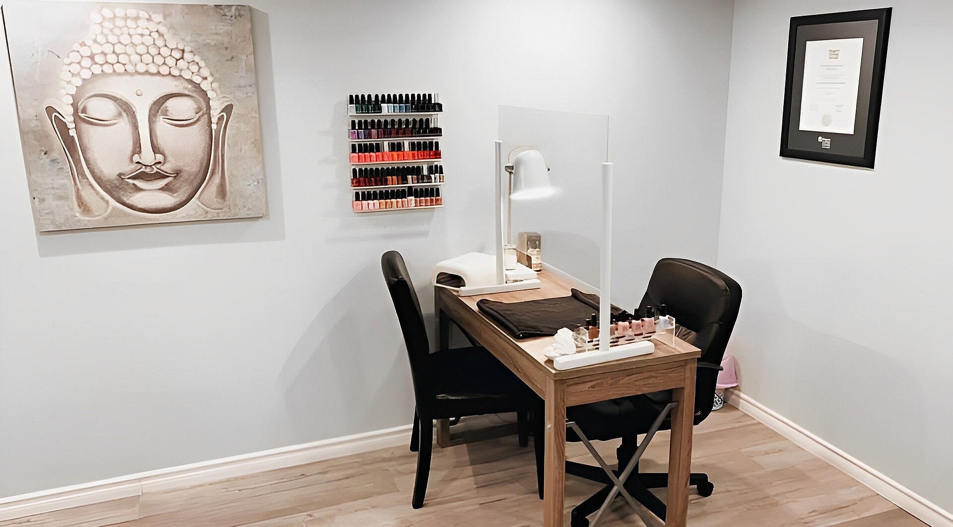 Nail station at Esthetics by Nikki in Hamilton, Ontario, CA, featuring a serene Buddha painting.