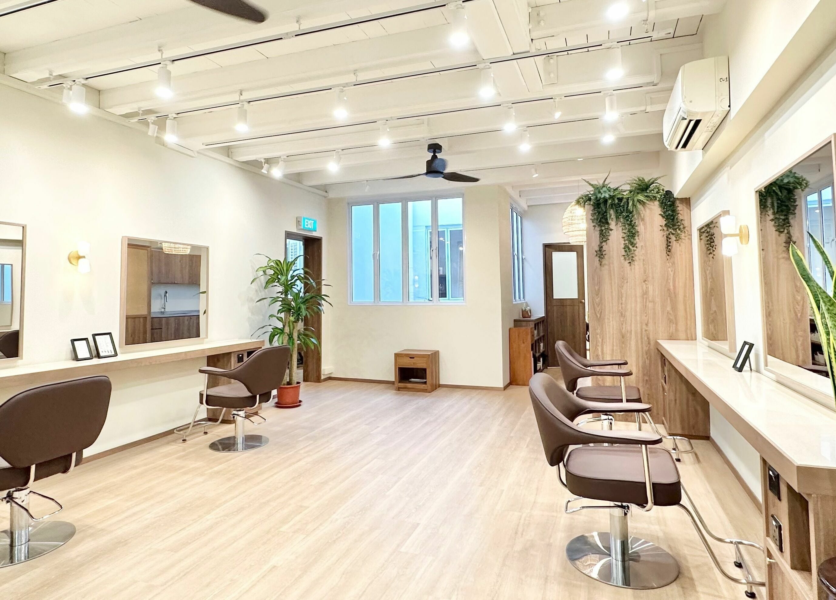 Modern interior of Hairstudio Flamingo - Tanjong Pagar in Singapore, featuring sleek styling chairs and natural decor.