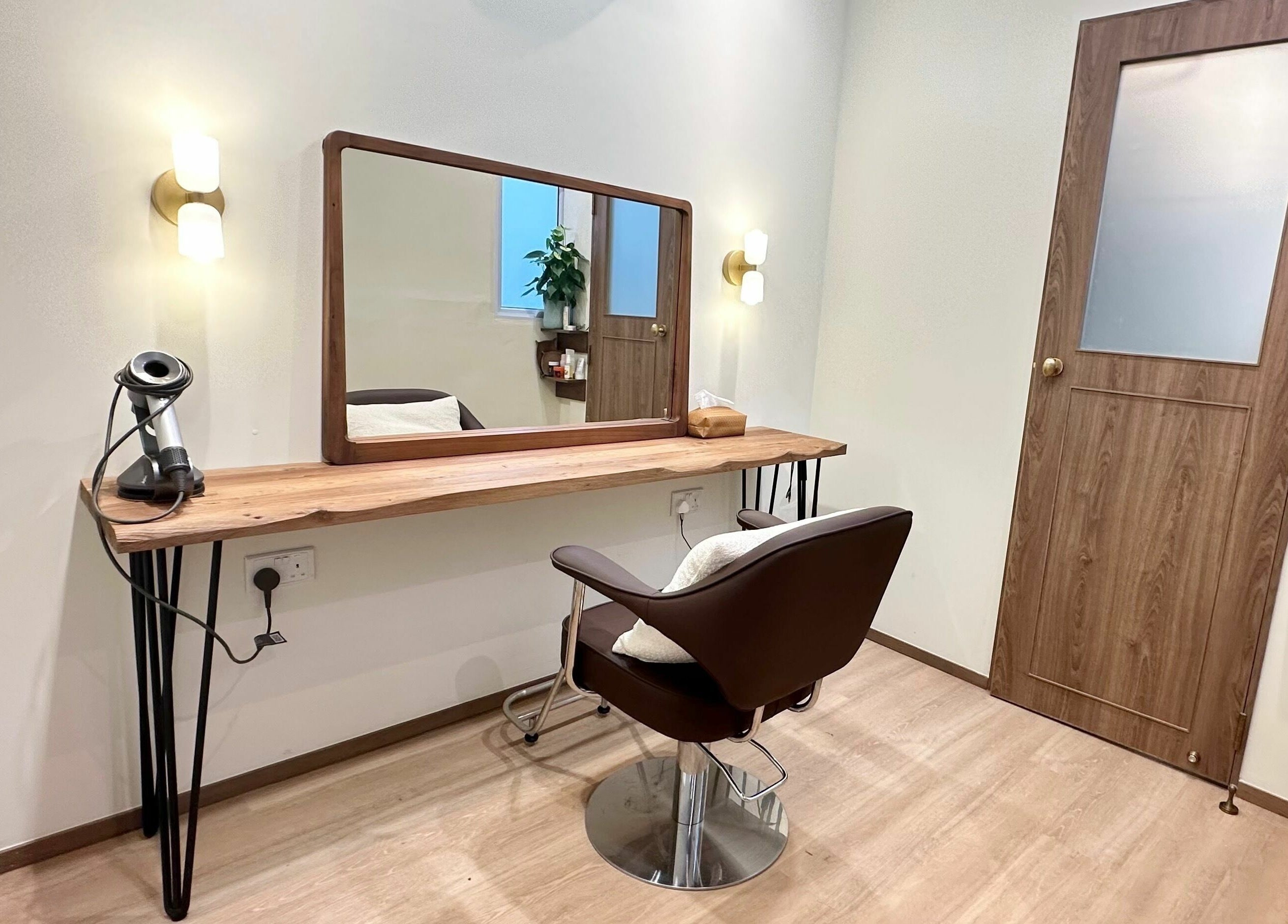Cozy styling area at Hairstudio Flamingo - Tanjong Pagar, Singapore, featuring a mirror and salon chair.
