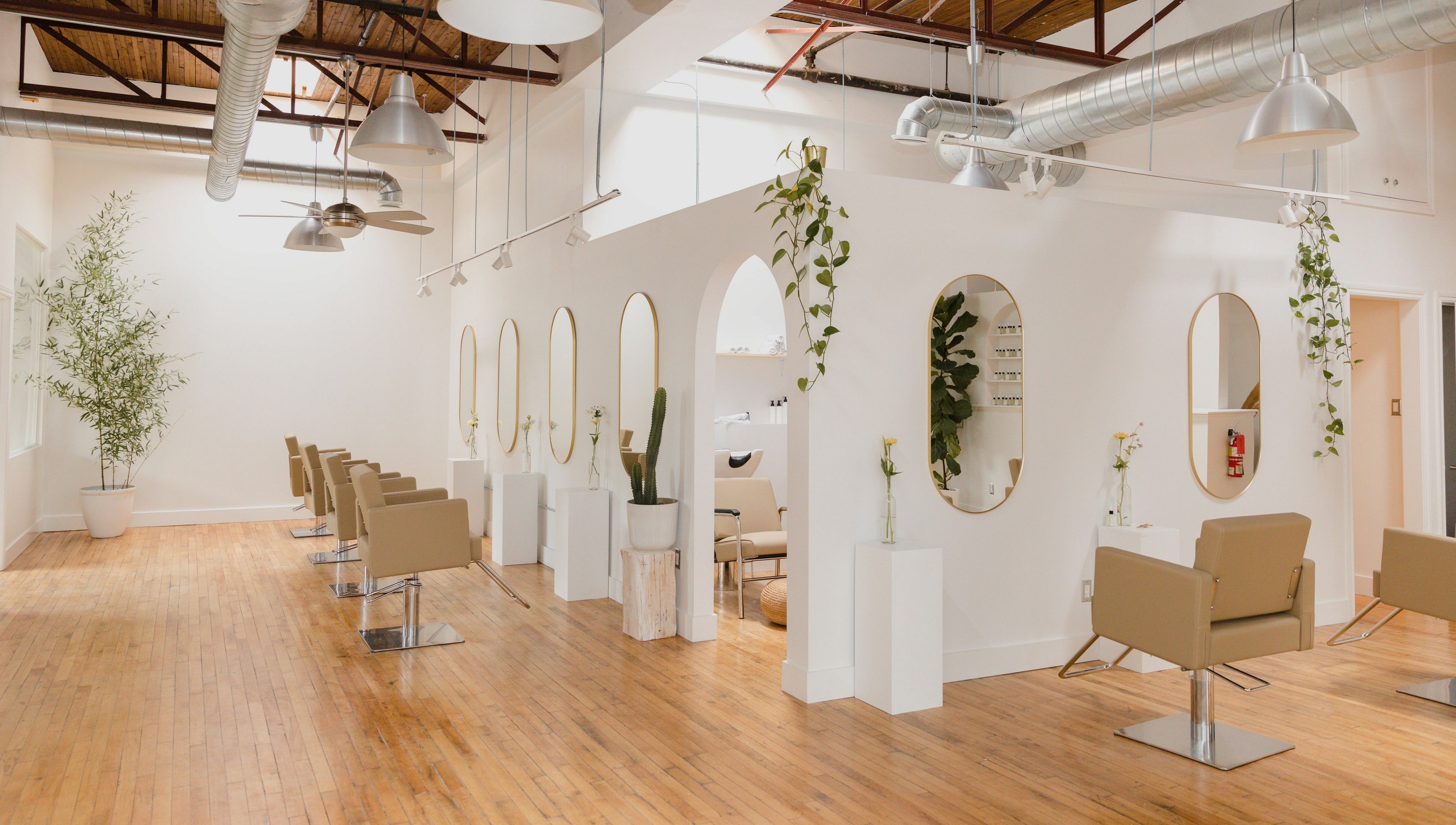 Modern salon interior at THIC Studio, Toronto, Ontario, CA, with stylish chairs and lush plants.