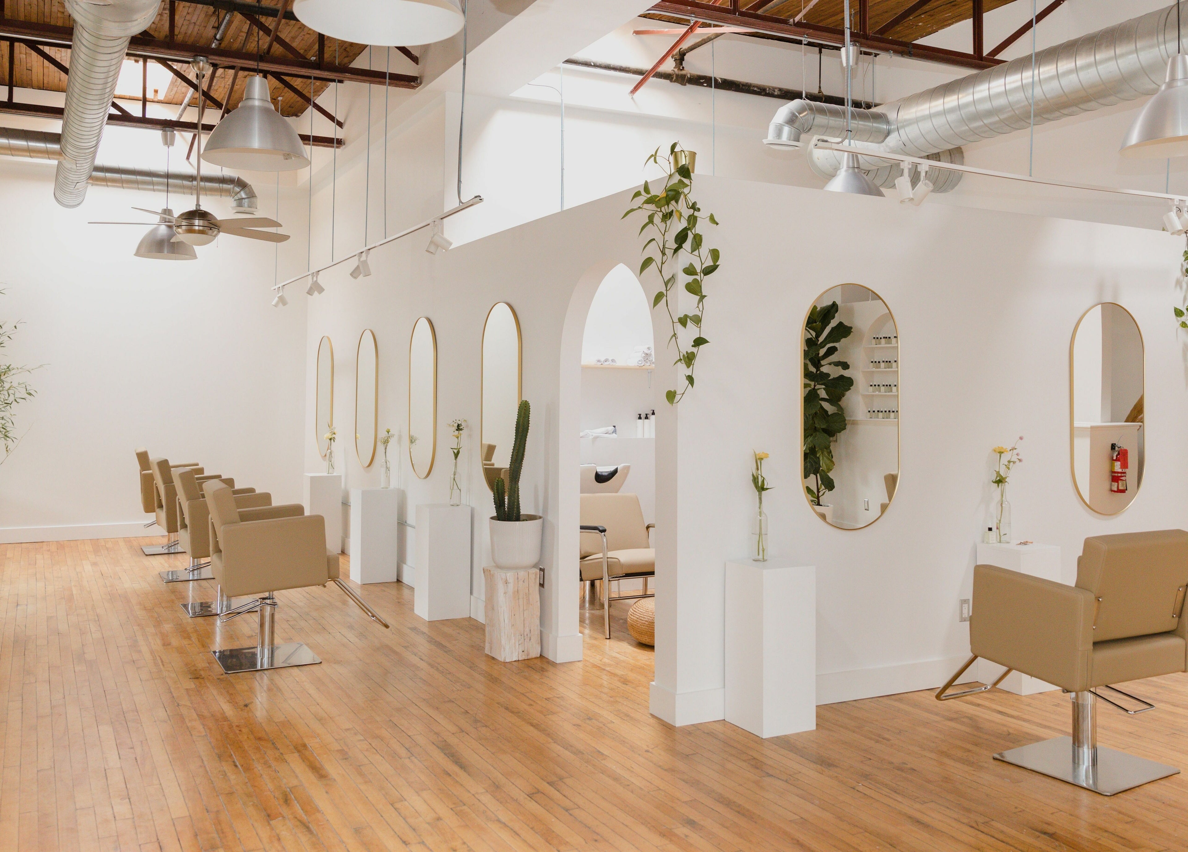 Modern salon interior at THIC Studio, Toronto, Ontario, CA, with stylish chairs and lush plants.