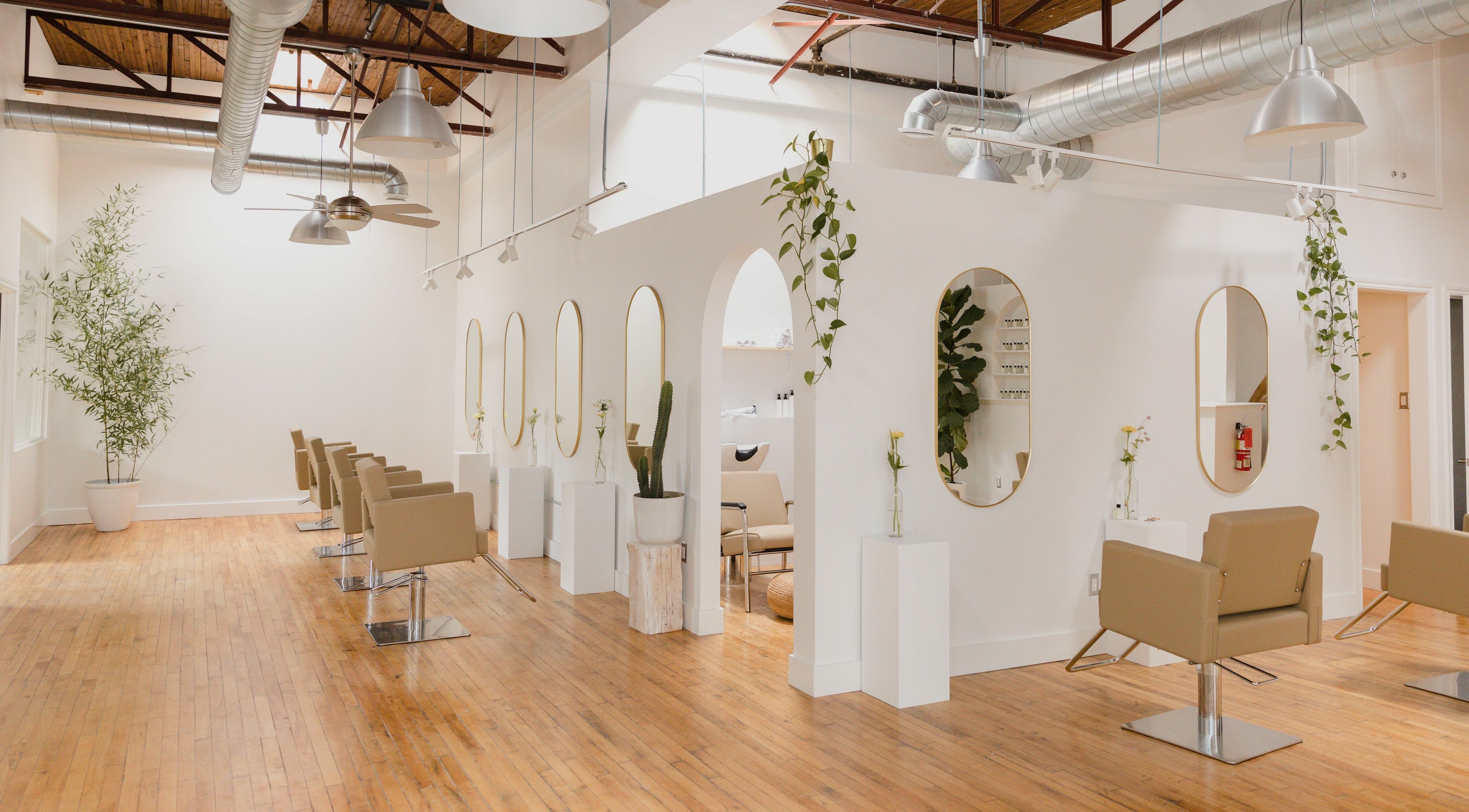 Modern salon interior at THIC Studio, Toronto, Ontario, CA, with stylish chairs and lush plants.