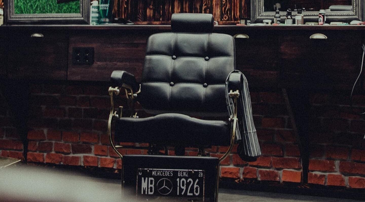 Elegant black barber chair at Alligator Barbers, Oslo, Oslo, NO, showcasing a classic grooming atmosphere.
