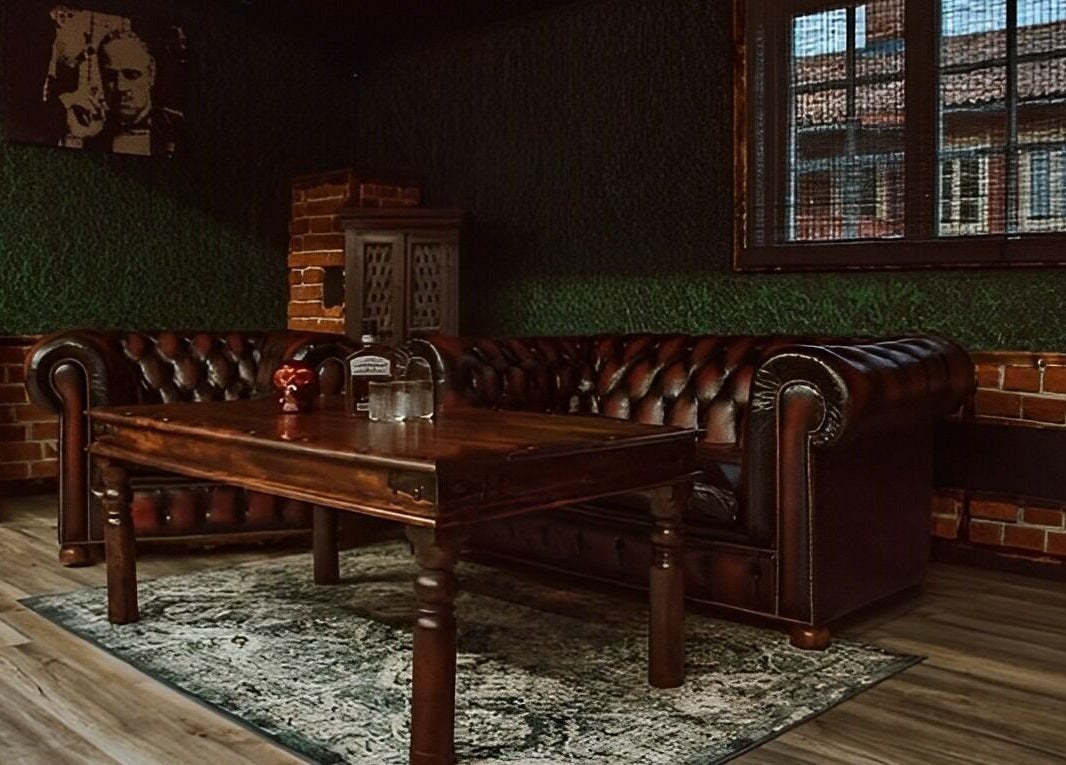 Cozy vintage lounge at Alligator Barbers, Oslo, Oslo, NO, featuring leather sofas and rustic decor.