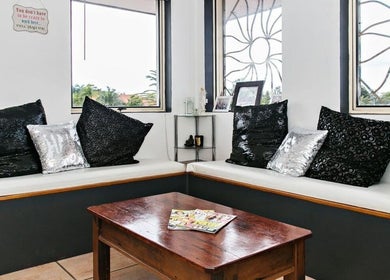 Stylish waiting area at Eye on Beauty, Bundall, Queensland, AU with black and silver cushions.