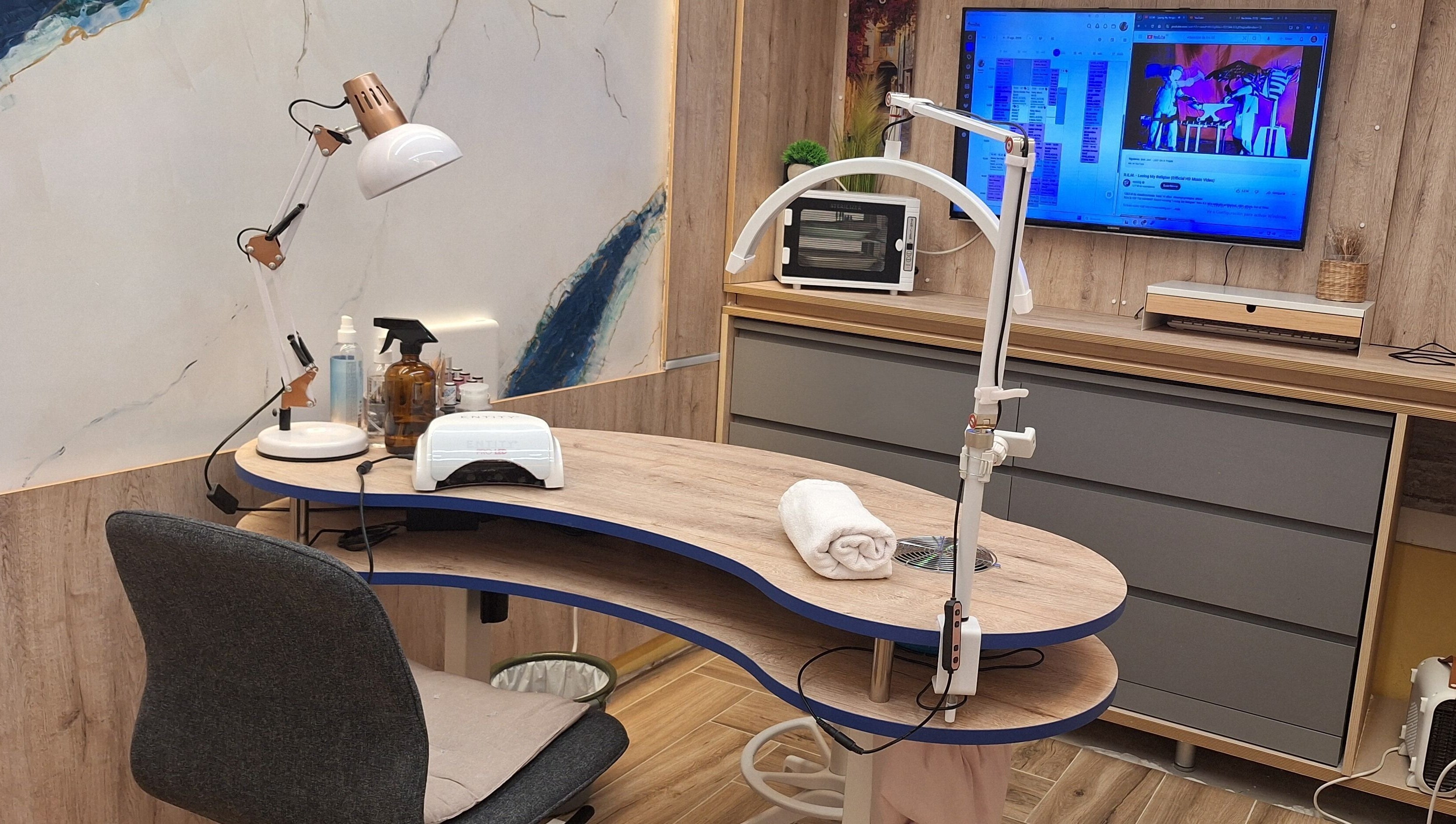 Mesa de manicura en Sandra Nails, Madrid, Comunidad De Madrid, ES, con lámpara y pantalla moderna.