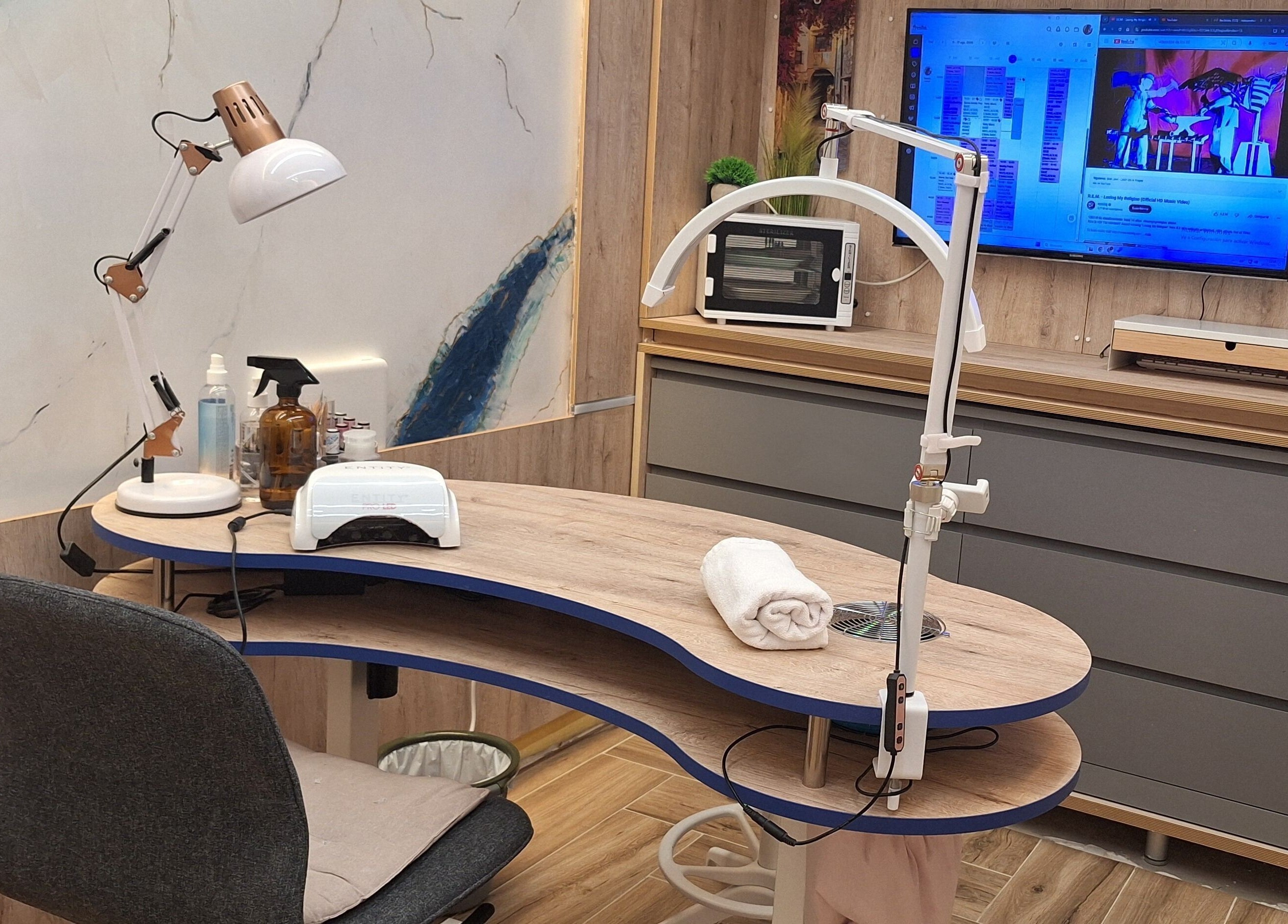 Mesa de manicura en Sandra Nails, Madrid, Comunidad De Madrid, ES, con lámpara y pantalla moderna.