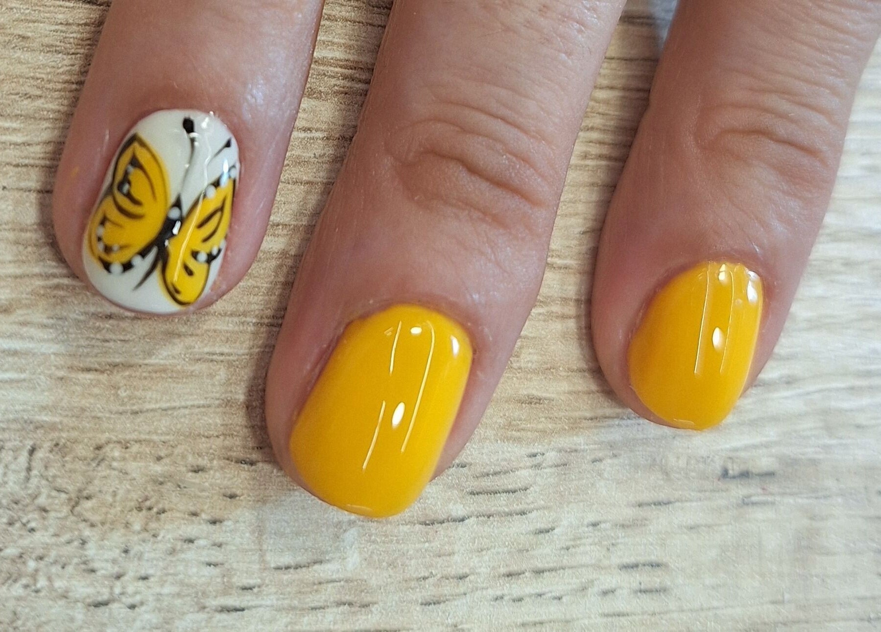 Arte de uñas amarillas con mariposa en Sandra Nails, Madrid, Comunidad De Madrid, ES.