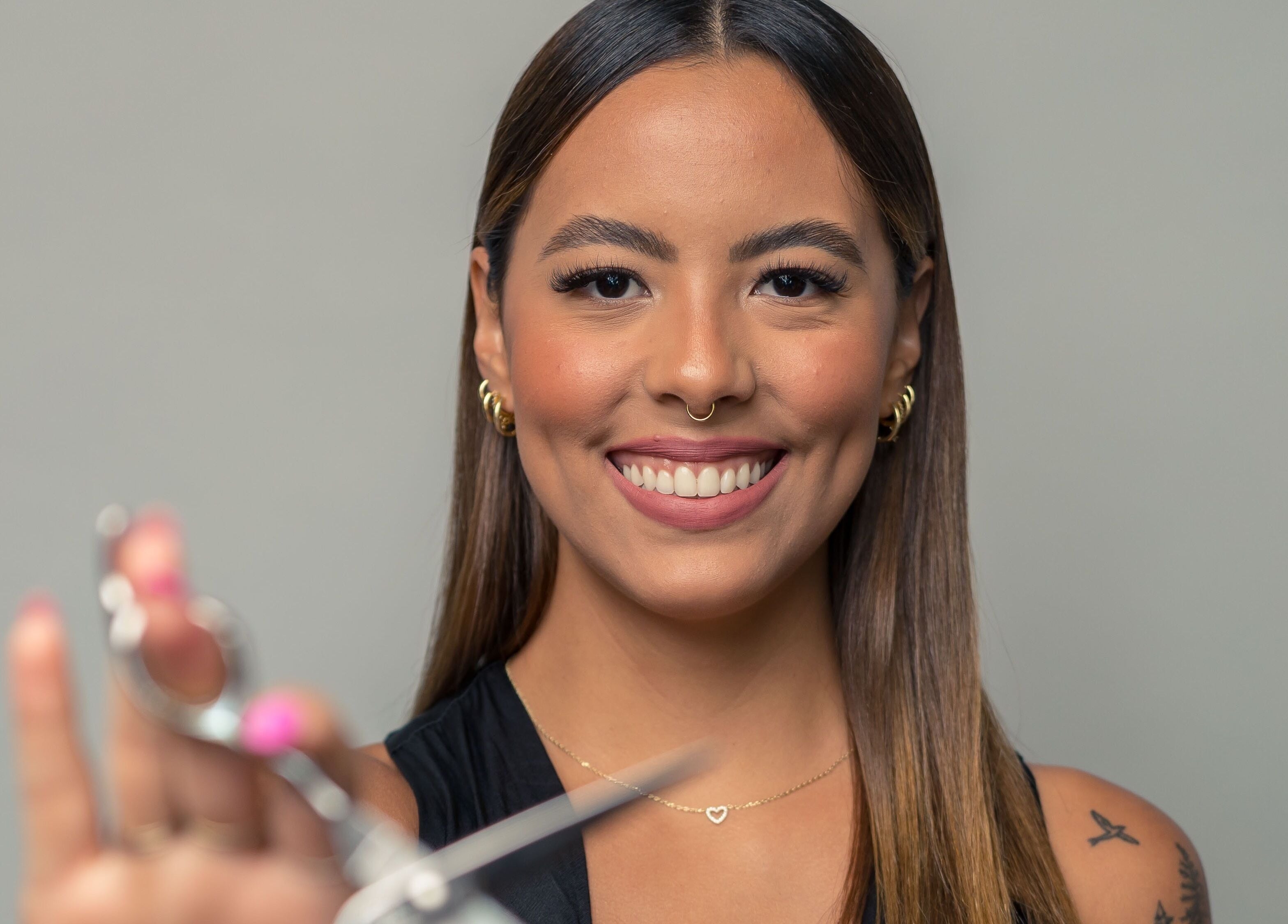 Smiling stylist with scissors at Team Lilian Sanchez, Katy, Texas, US.