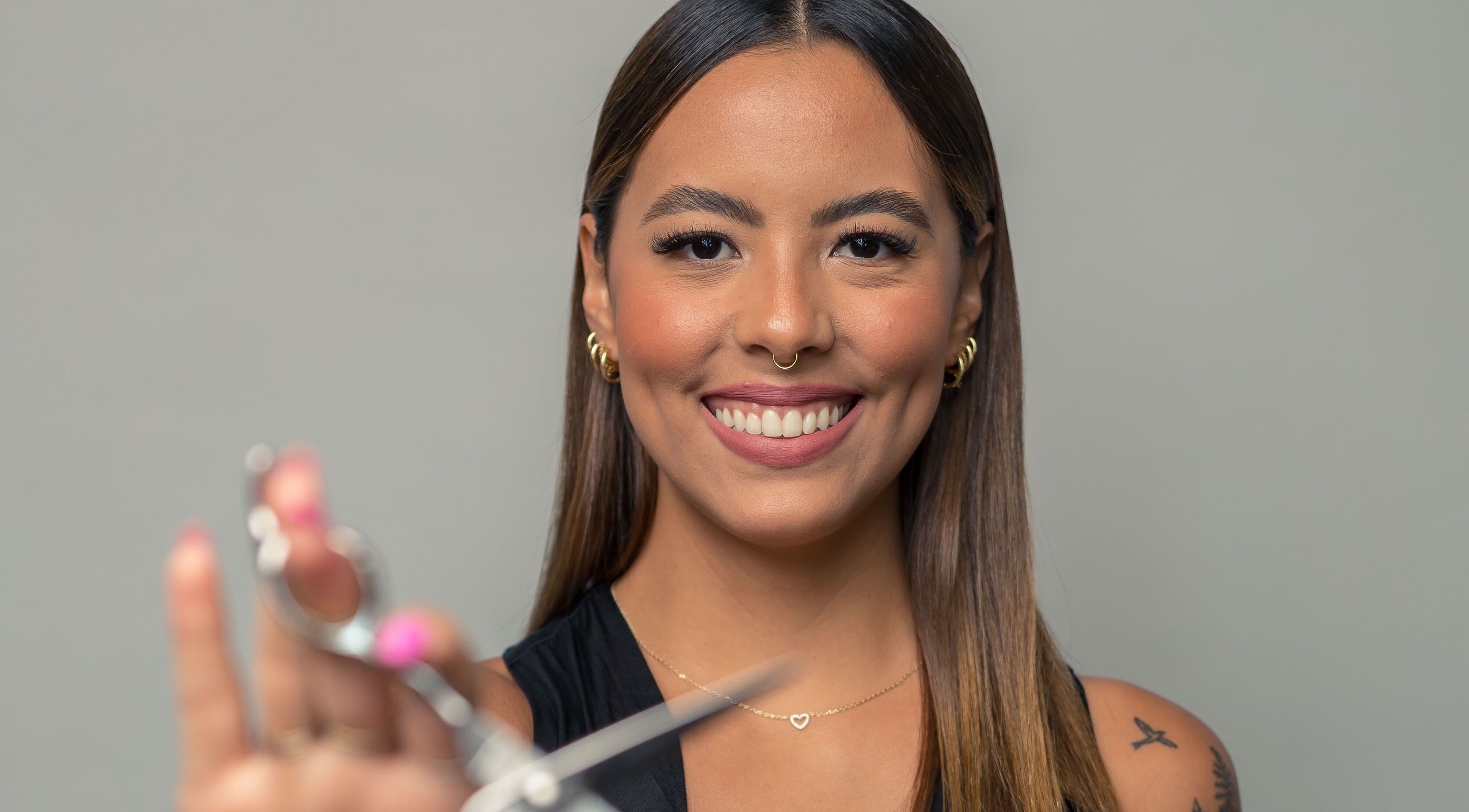 Smiling stylist with scissors at Team Lilian Sanchez, Katy, Texas, US.