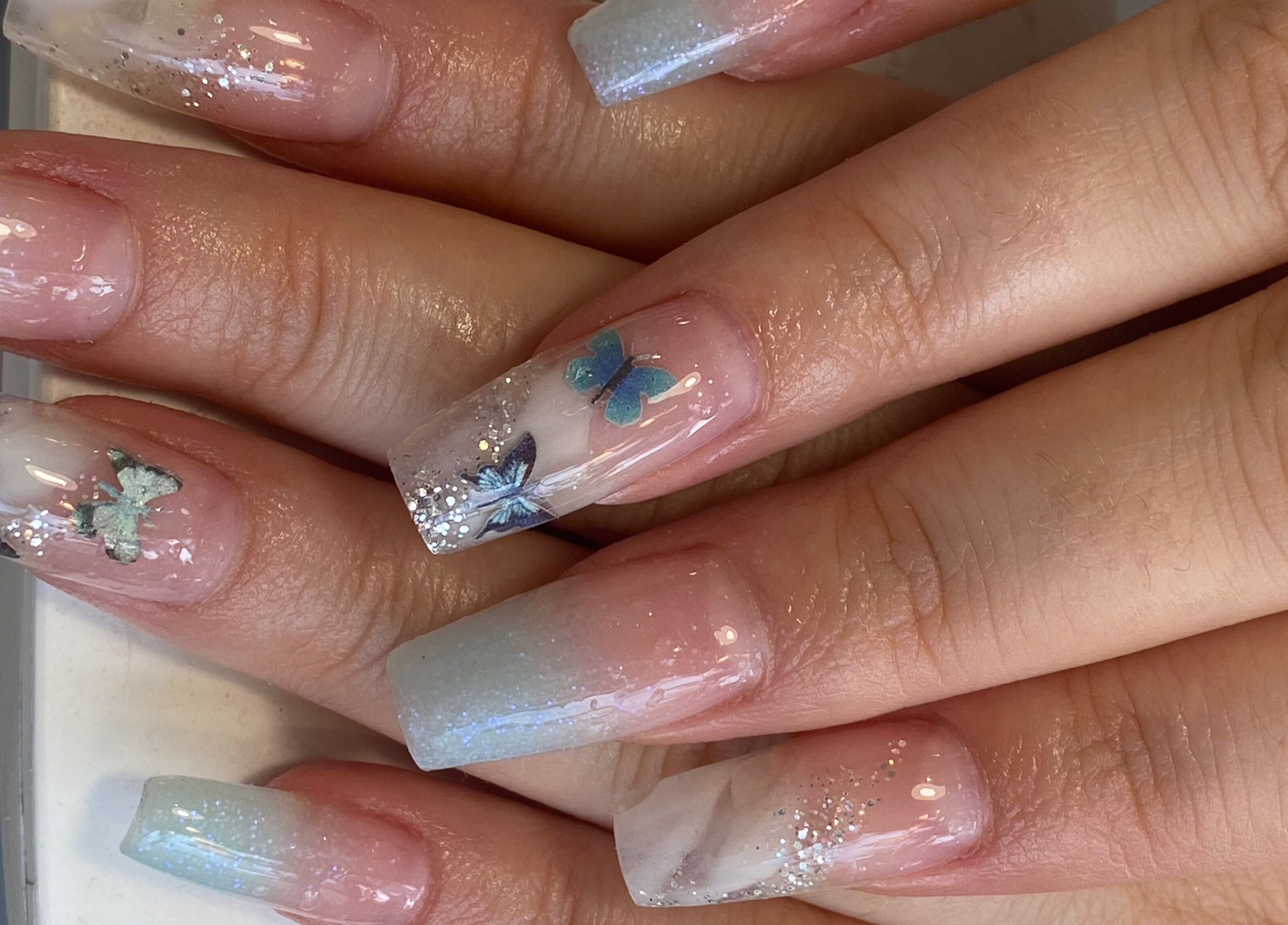 Elegant butterfly nail art at Rose Nails, Barking, England, GB showcasing intricate design and shimmering details.