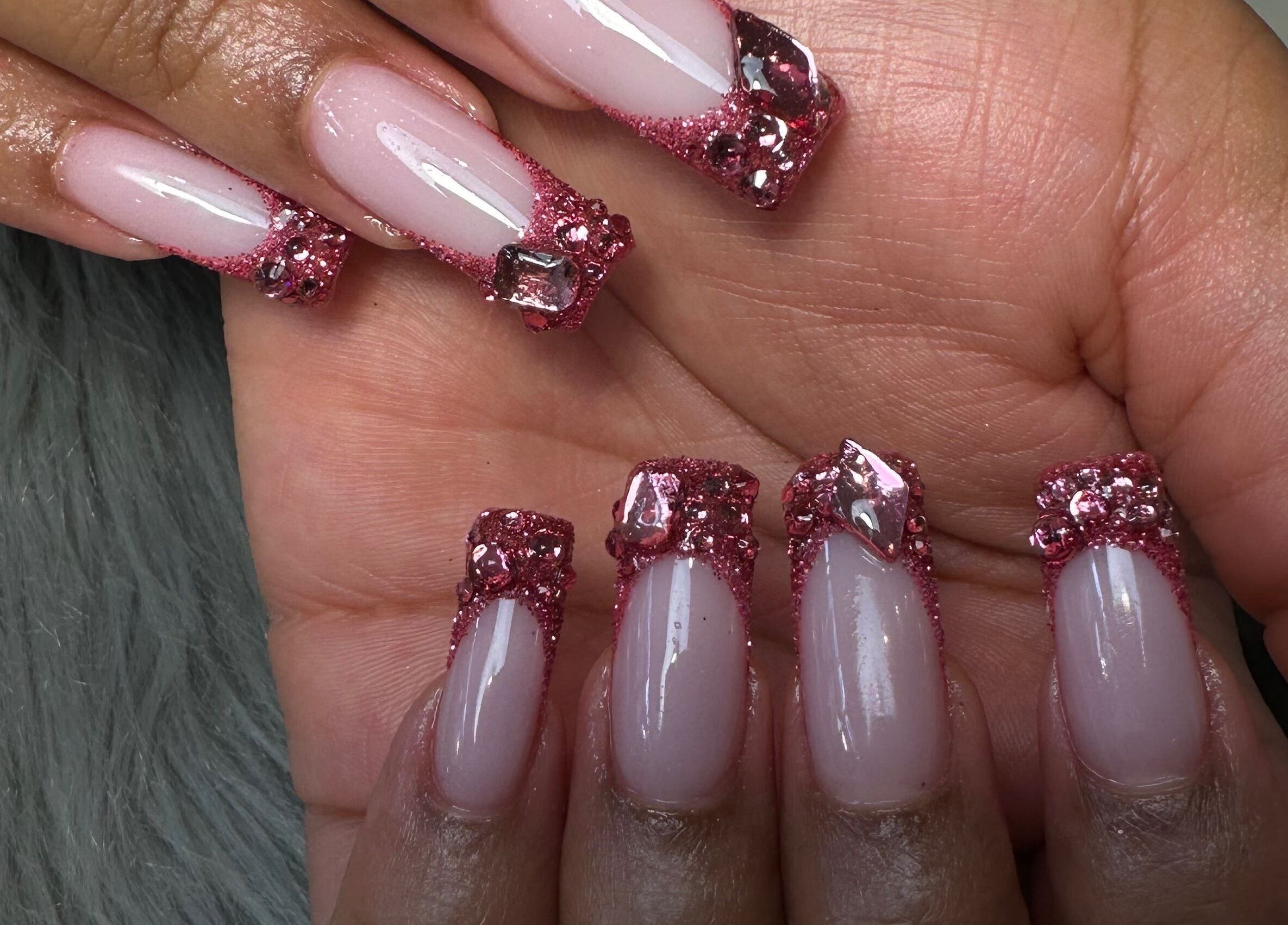 Close-up of glam glitter nail art at Rose Nails, Barking, England, GB. Sparkling pink designs shine brightly.