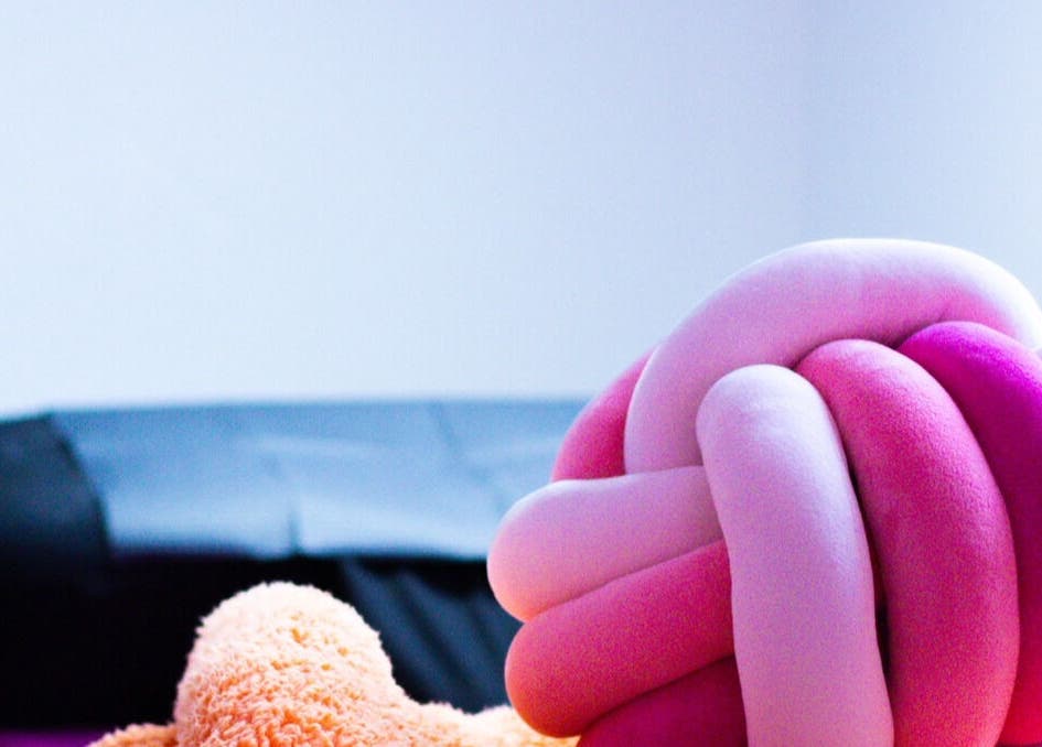 Plush pink and orange knot pillow in Gee’s Beauty Gloucester, Gloucester, England, GB spa room.