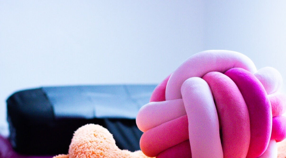 Plush pink and orange knot pillow in Gee’s Beauty Gloucester, Gloucester, England, GB spa room.