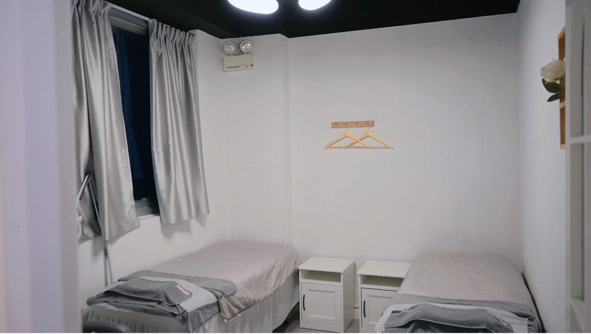 Twin beds in a serene room at MAM Beauty, 旺角, HK, offering a tranquil atmosphere for relaxation.