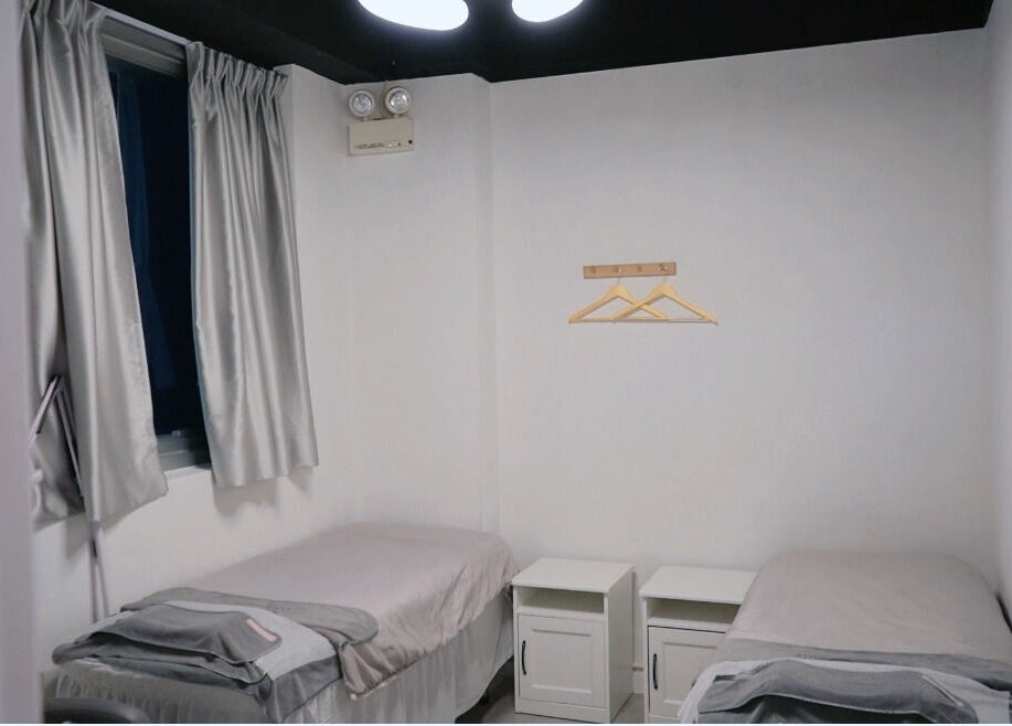 Twin beds in a serene room at MAM Beauty, 旺角, HK, offering a tranquil atmosphere for relaxation.