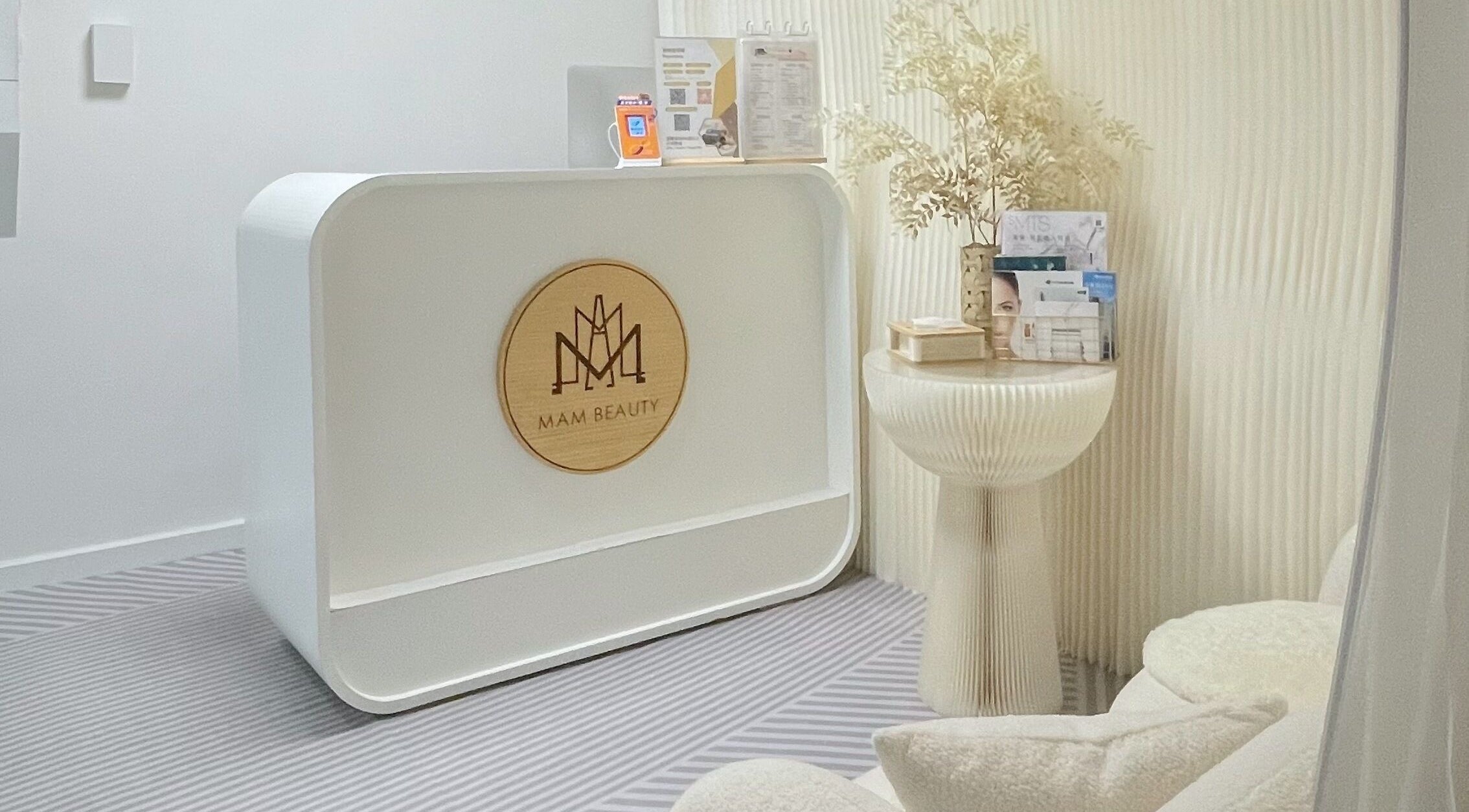 Modern reception at MAM Beauty, 旺角, HK. Features sleek desk with branding and decorative accents.