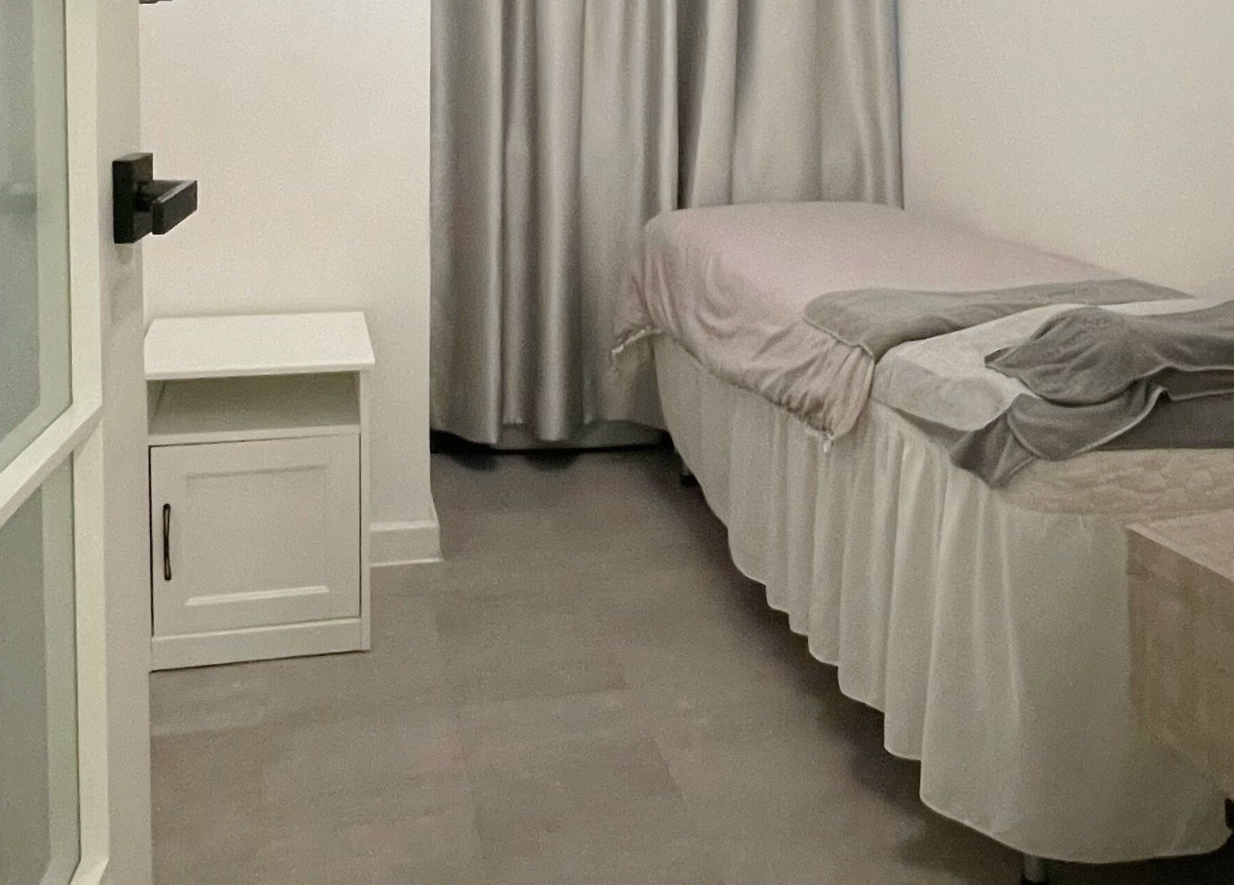 Calming treatment room at MAM Beauty, 旺角, HK with neatly arranged massage bed and soft curtains.