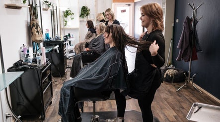 Stylist in Salon X, Taos, New Mexico, US, working on a client's hair, enhancing beauty and relaxation.