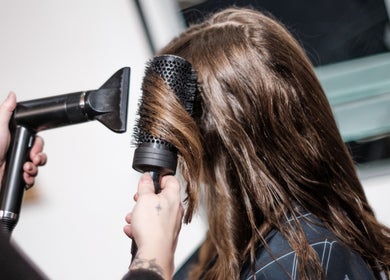 A stylist at Salon X, Taos, New Mexico, US, uses a blow dryer and round brush for a seamless hair blowout.