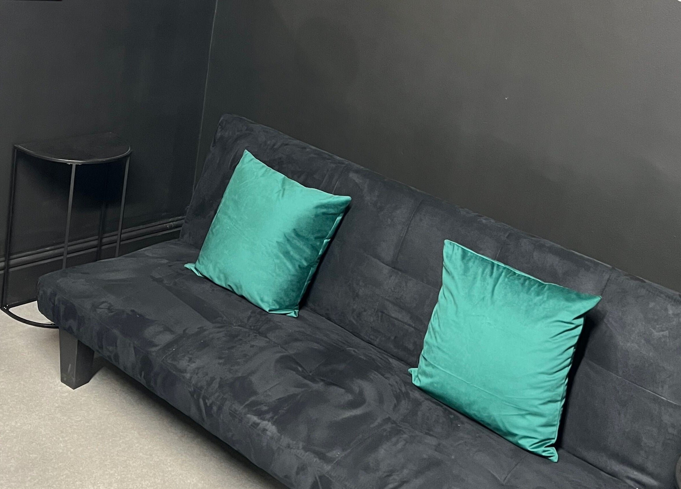 Chic black sofa with teal pillows in Tiny Face / Steph, Guisborough, England, GB.