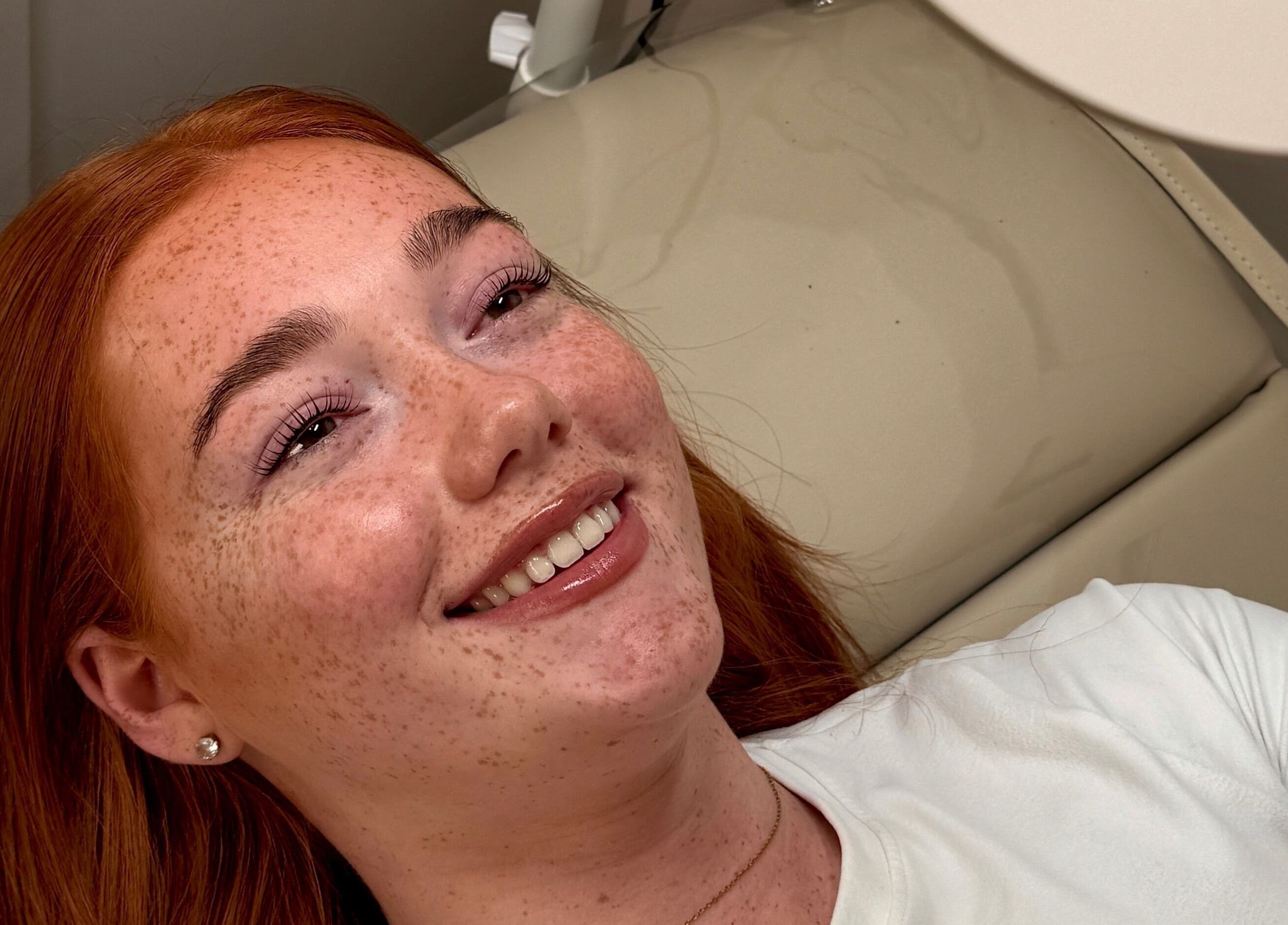 Client with radiant smile at Crown By Chloe in Dundee, Scotland, GB. Beauty and relaxation in serene setting.