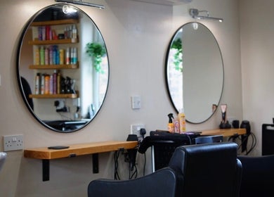 Modern styling stations at Head Quarters Hair and Beauty Salon, Thorngumbald, England, GB, with circular mirrors.