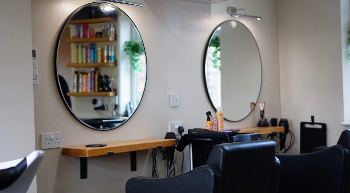 Modern styling stations at Head Quarters Hair and Beauty Salon, Thorngumbald, England, GB, with circular mirrors.