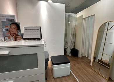 Reception area of BeauteArt Skincare in Singapore, showcasing chic decor and a standing mirror.