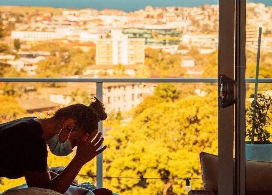 Therapist at Minty Massage (Home visit) provides chair massage with Sydney skyline view in Bondi Junction, New South Wales, AU.