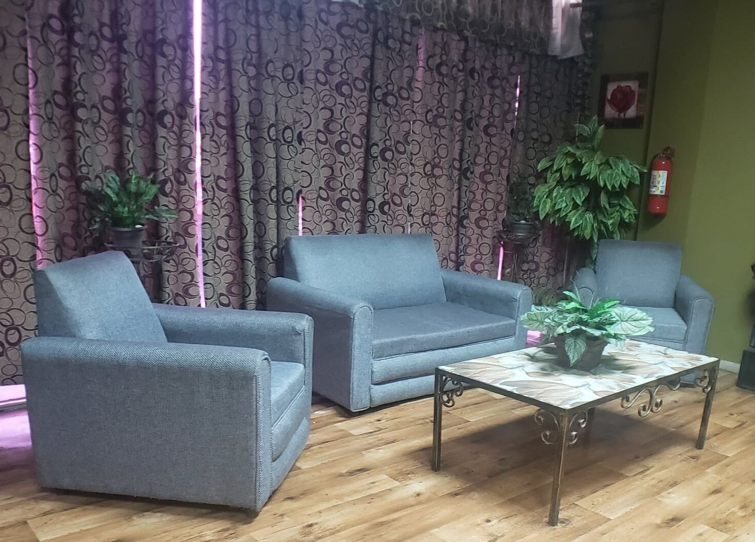 Cozy lounge area with grey seating at InnoSense Salon and Med Spa, St. James, TT.