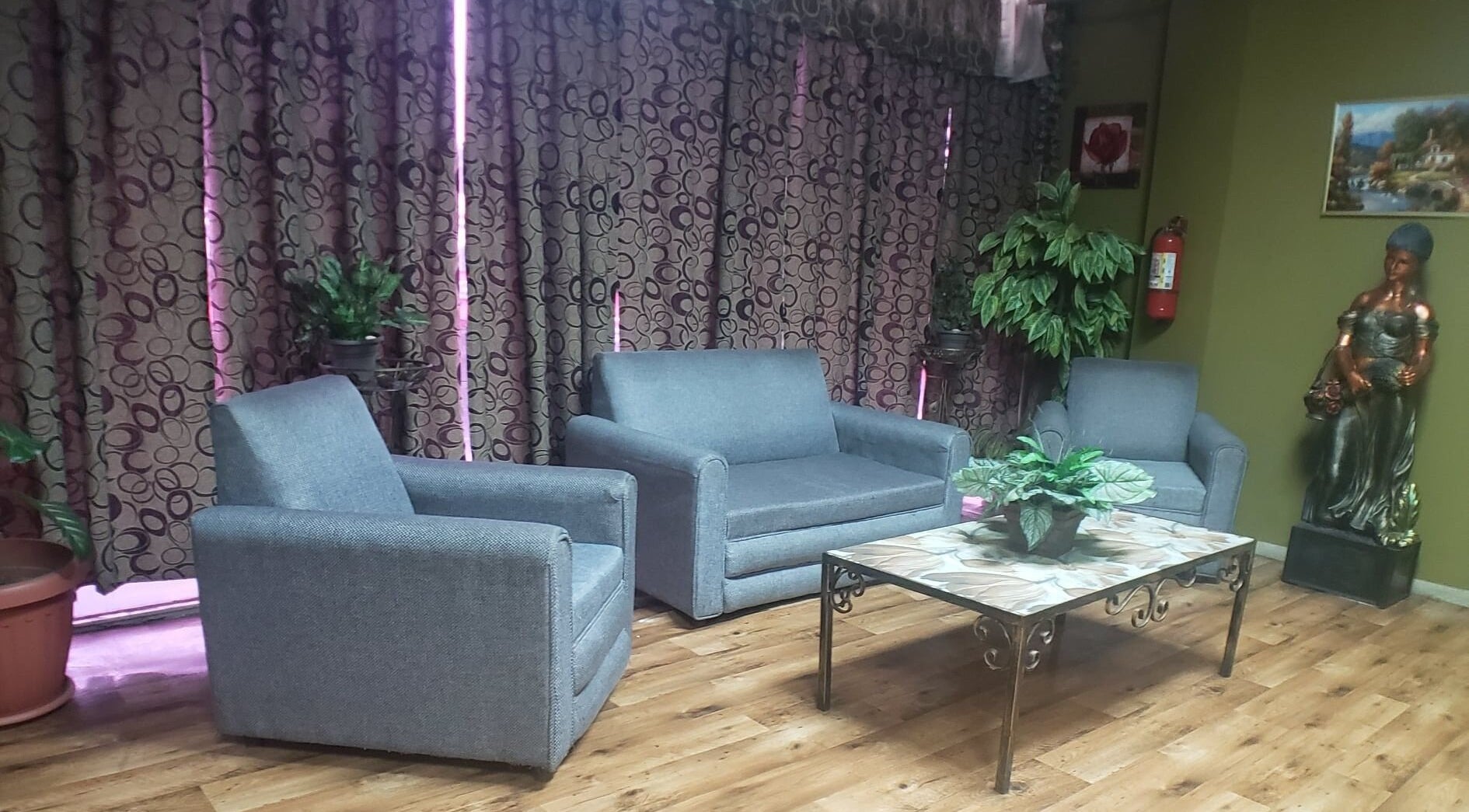Cozy lounge area with grey seating at InnoSense Salon and Med Spa, St. James, TT.