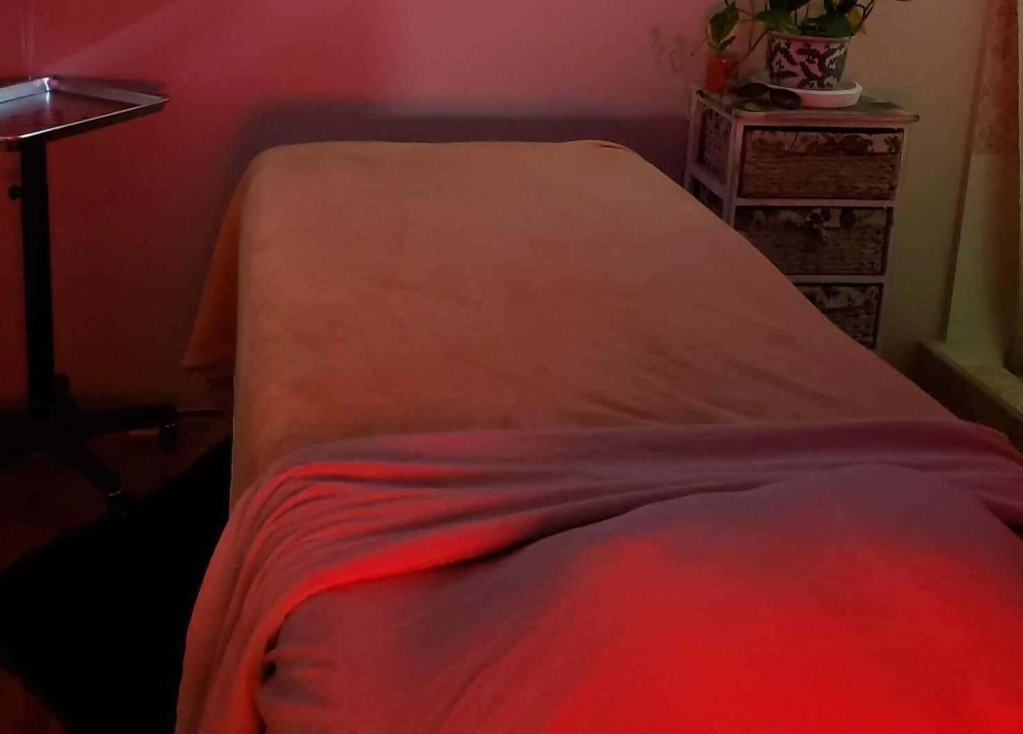 Peaceful massage room in InnoSense Salon and Med Spa, St. James, TT with soft lighting and cozy bed.