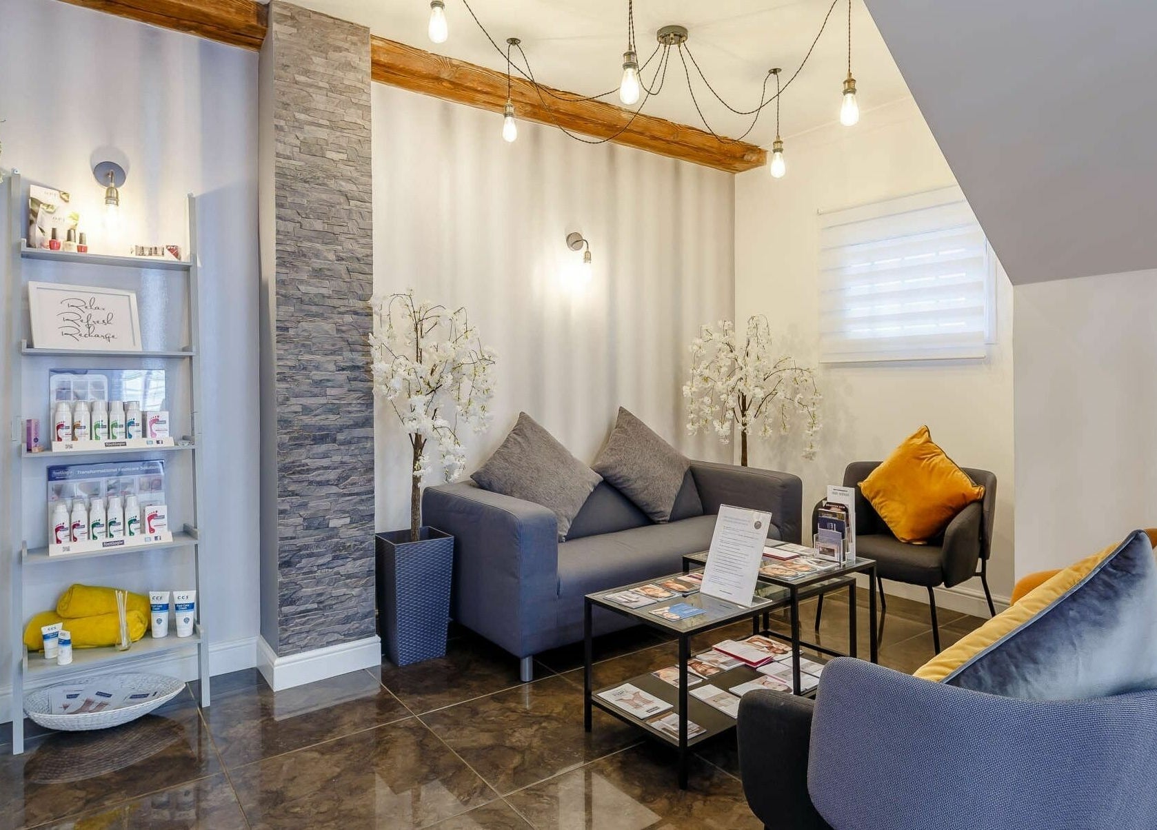 Cozy seating area with grey sofas and decor at Harmony Day Spa Royston, Royston, England, GB.
