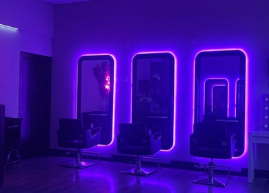 Chic neon-lit salon interior at Blossom Beauty, Dublin, County Dublin, IE, featuring stylish mirrors and chairs.