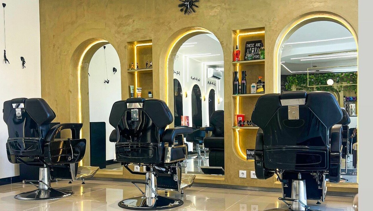 Interior elegante do The Mani Pedi Spa Maputo com cadeiras pretas e espelhos sofisticados em Maputo, Maputo, MZ.